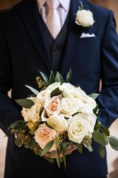 lisa stoner event planning - best wedding planner in orlando - groom in a blue suit- groom holding brides bouquet- white and blush bridal bouquet.jpg